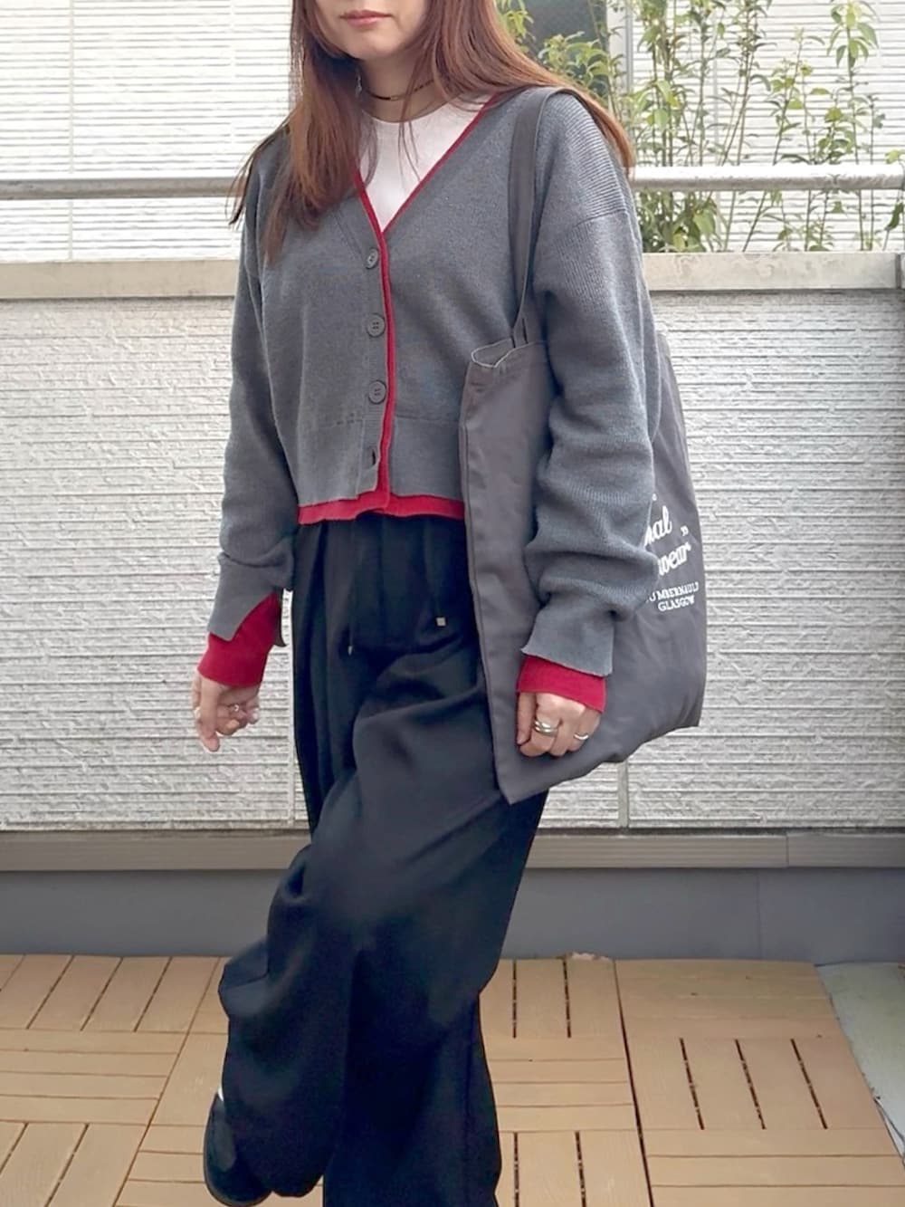 グレー系のカーディガン/ボレロ、ブラック系のスラックス、ブラック系のスニーカーを着用したレディースの春コーディネートの4枚目の写真