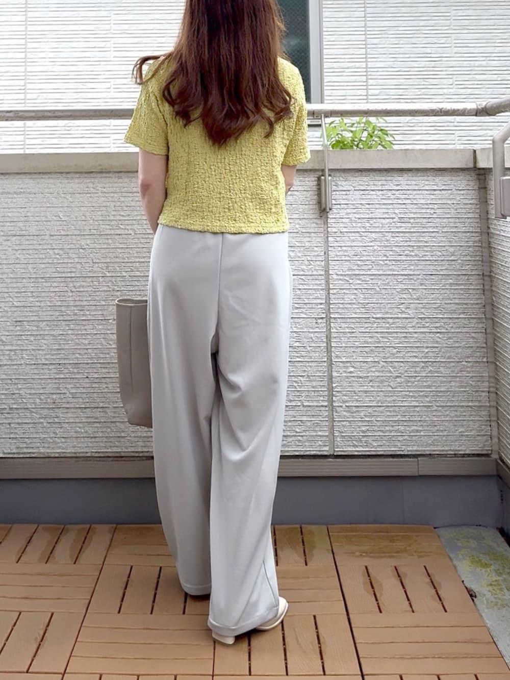 グリーン系のTシャツ/カットソー、グレー系のスラックス、ゴールド系のアナログ腕時計を着用したレディースの夏コーディネートの4枚目の写真