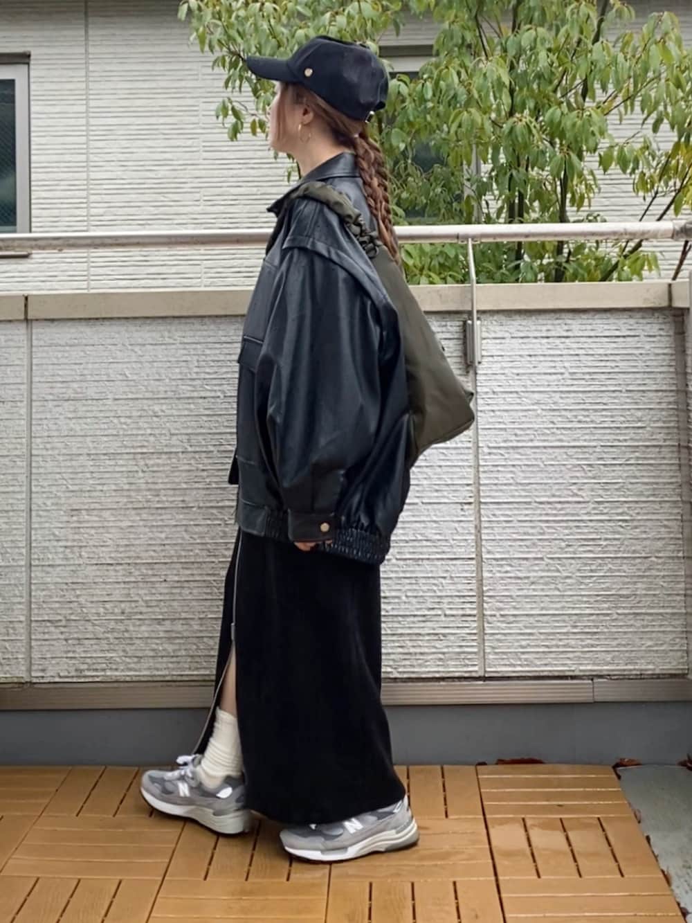 ブラック系のライダースジャケット、ホワイト系のスウェット、ブラック系のスカートを着用したレディースの春コーディネートの2枚目の写真