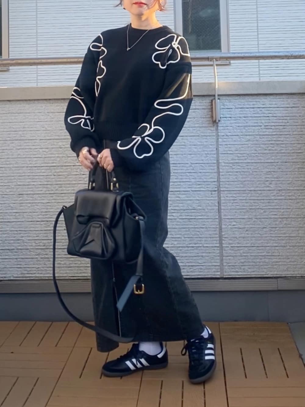 ブラック系のニット/セーター、ブラック系のブルゾン、ブラック系のスカートを着用したレディースの冬コーディネートの3枚目の写真