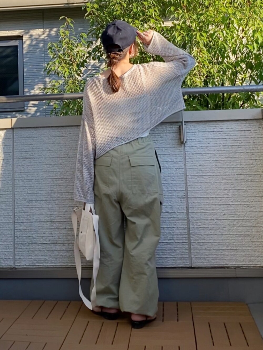 グレー系のカーディガン/ボレロ、ホワイト系のキャミソール、ベージュ系のカーゴパンツを着用したレディースの夏コーディネートの3枚目の写真