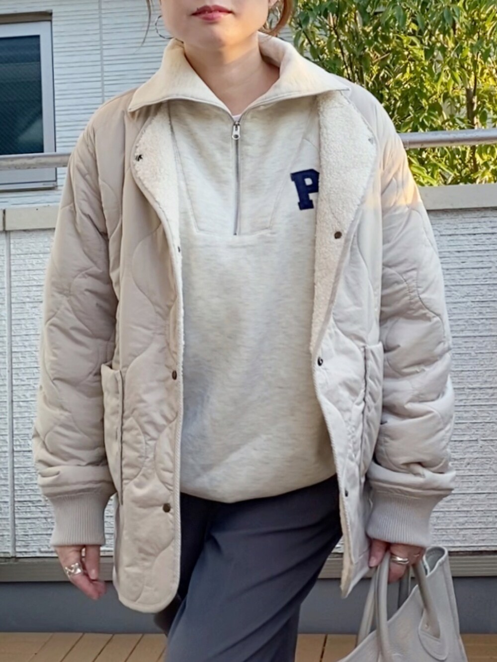 ベージュ系のブルゾン、ベージュ系のスウェット、グレー系のスラックスを着用したレディースの秋コーディネートの4枚目の写真