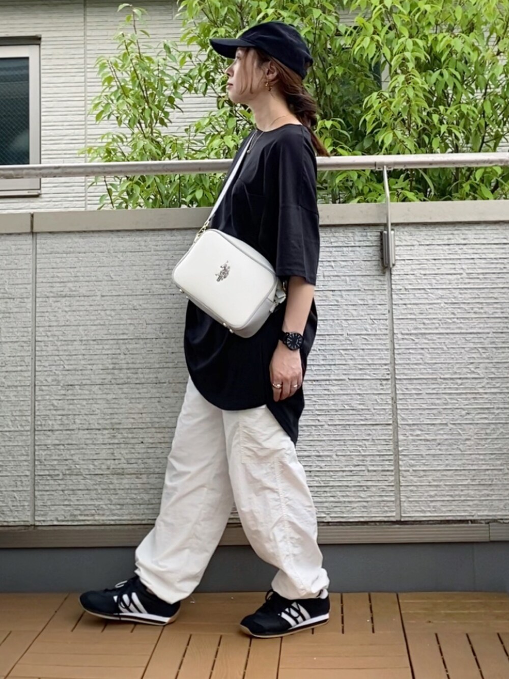 ブラック系のTシャツ/カットソー、ホワイト系のその他パンツ、ホワイト系のショルダーバッグを着用したレディースの夏コーディネートの2枚目の写真