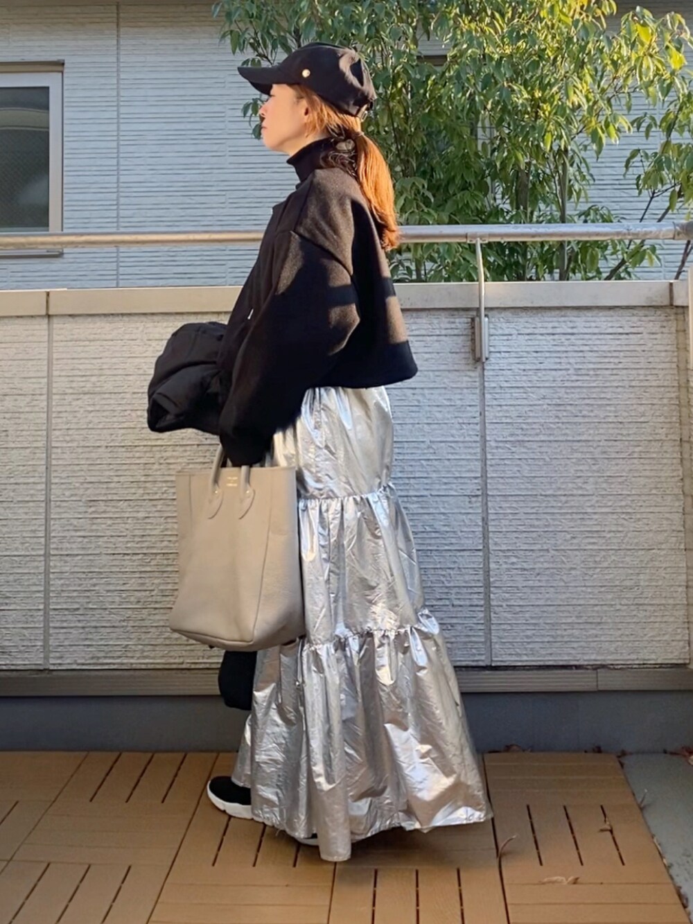 ブラック系のワンピース、ブラック系のニット/セーター、ブラック系のダウンジャケット/コートを着用したレディースの冬コーディネートの2枚目の写真