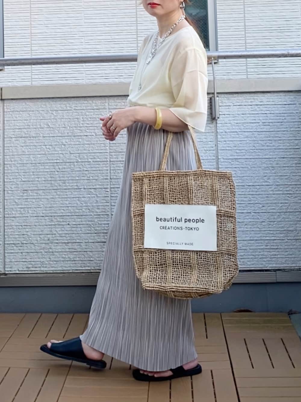 ホワイト系のシャツ/ブラウス、グレー系のスカート、シルバー系のピアス（両耳用）を着用したレディースの夏コーディネートの3枚目の写真