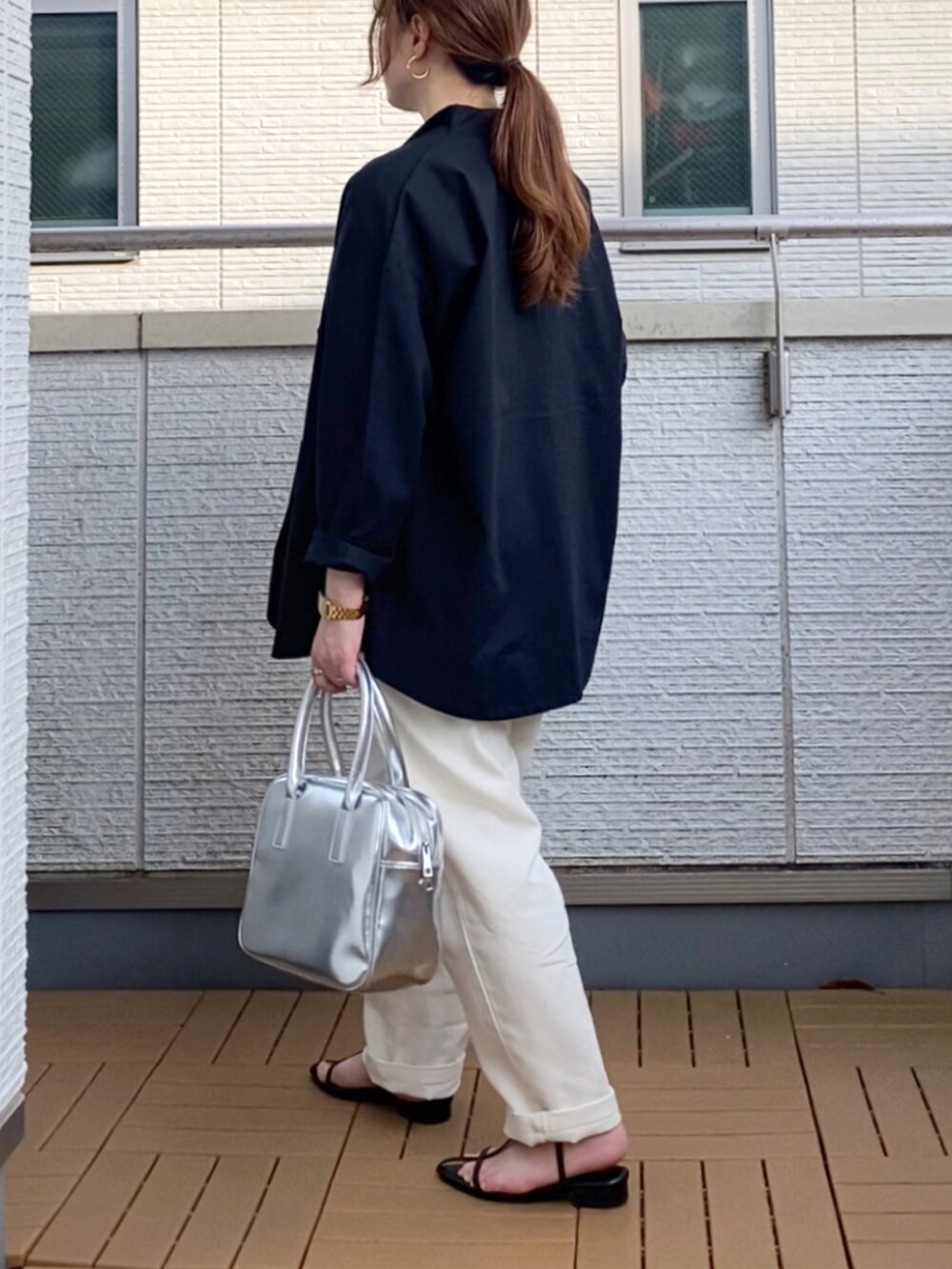 ブラック系のテーラードジャケット、ホワイト系のその他パンツ、シルバー系のボストンバッグを着用したレディースの春コーディネートの4枚目の写真