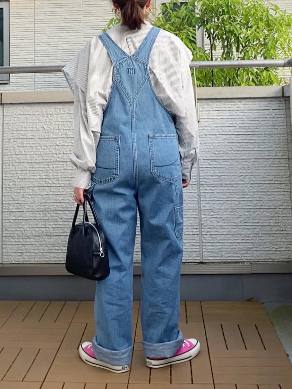 ブルー系のサロペット/オーバーオール、ブラック系のシャツ/ブラウス、ブラック系のショルダーバッグを着用したレディースの春コーディネートの2枚目の写真