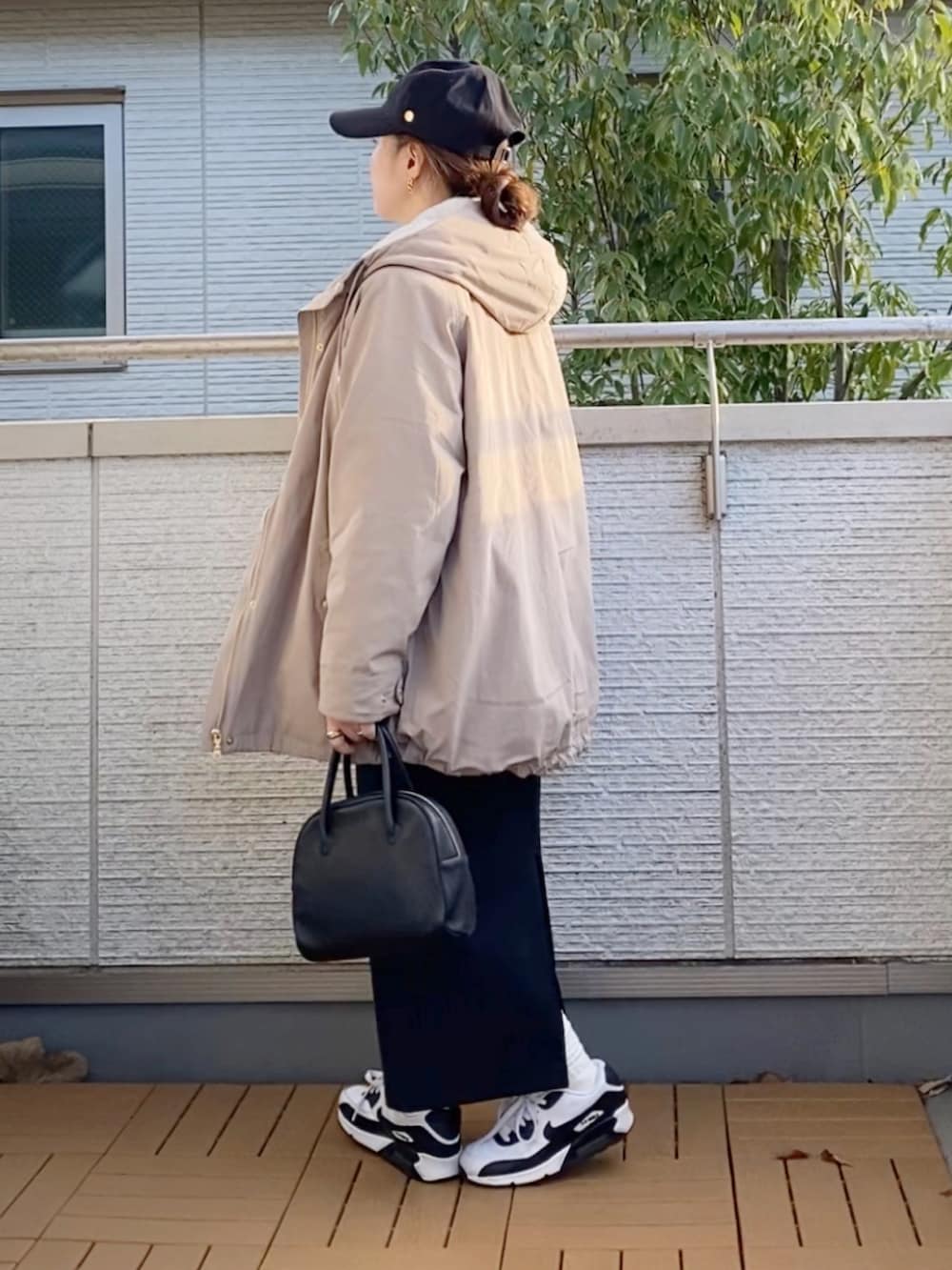 ベージュ系のマウンテンパーカー、ホワイト系のスウェット、ブラック系のスカートを着用したレディースの冬コーディネートの2枚目の写真