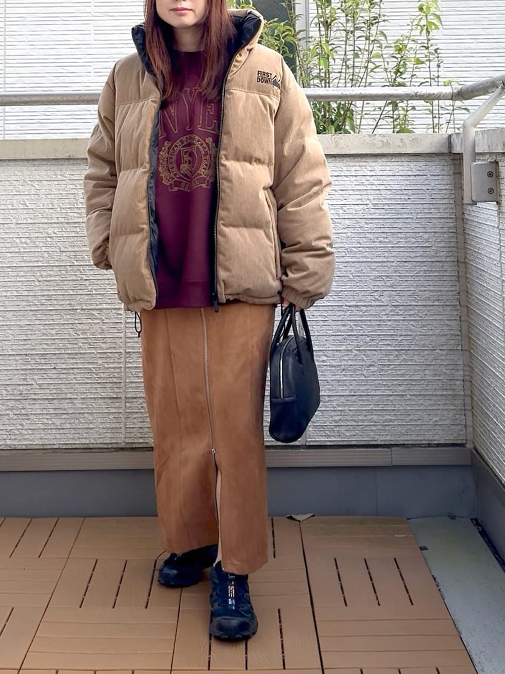 ベージュ系のダウンジャケット/コート、ブラック系のスカート、レッド系のスウェットを着用したレディースの秋コーディネートの2枚目の写真