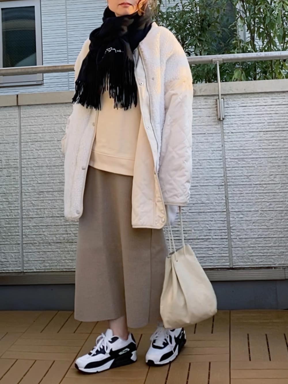 ホワイト系のノーカラージャケット、ホワイト系のスウェット、ベージュ系のスカートを着用したレディースの冬コーディネートの2枚目の写真