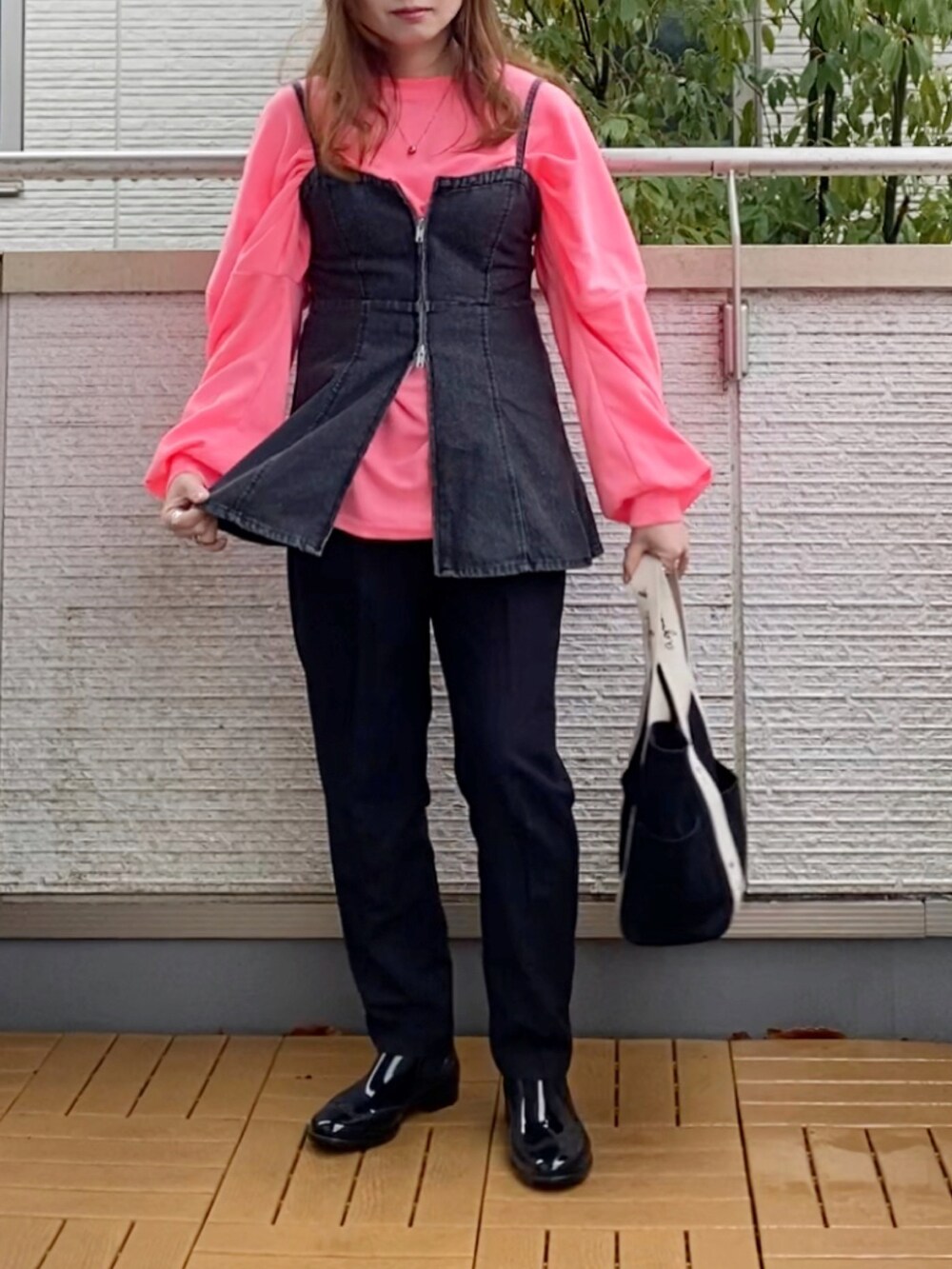 ピンク系のTシャツ/カットソー、ブラック系のベスト、ブラック系のその他パンツを着用したレディースの春コーディネートの3枚目の写真