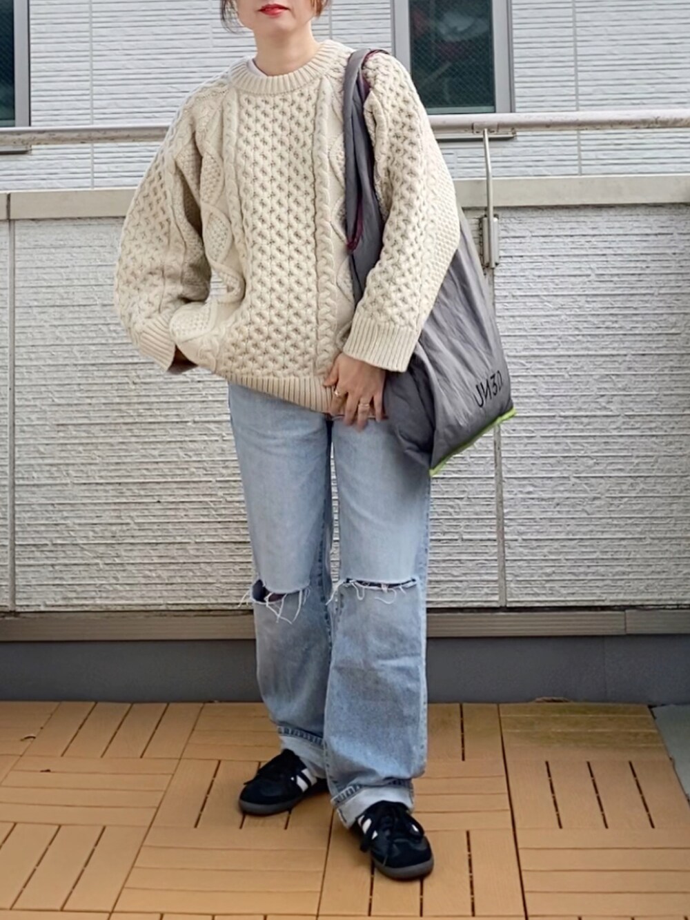 ホワイト系のニット/セーター、ブルー系のデニムパンツ、グレー系のトートバッグを着用したレディースの秋コーディネートの2枚目の写真
