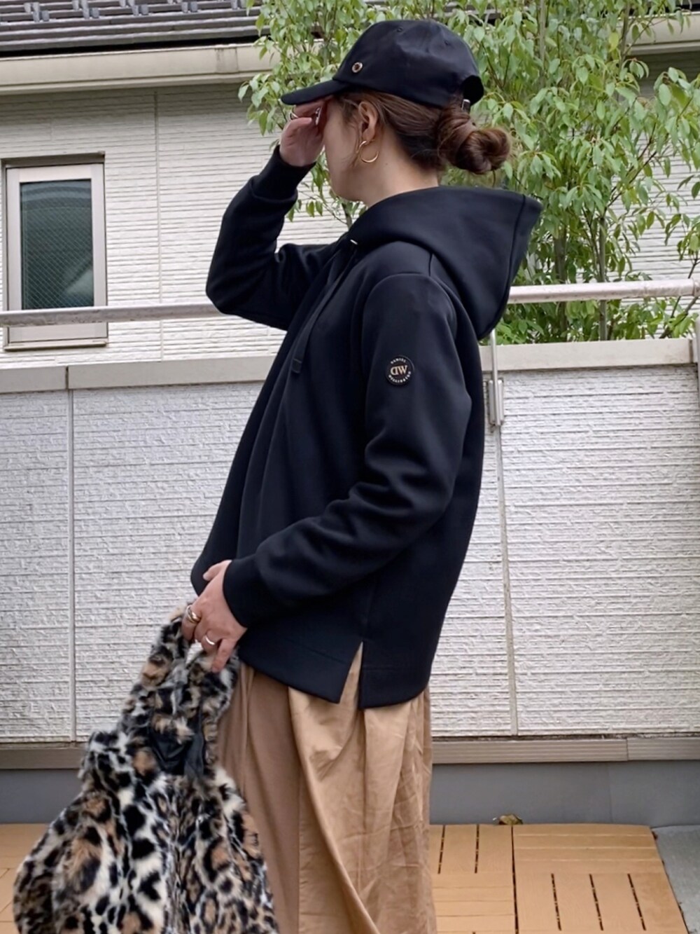 ブラック系のパーカー、ベージュ系のワンピース、その他のハンドバッグを着用したレディースの秋コーディネートの2枚目の写真