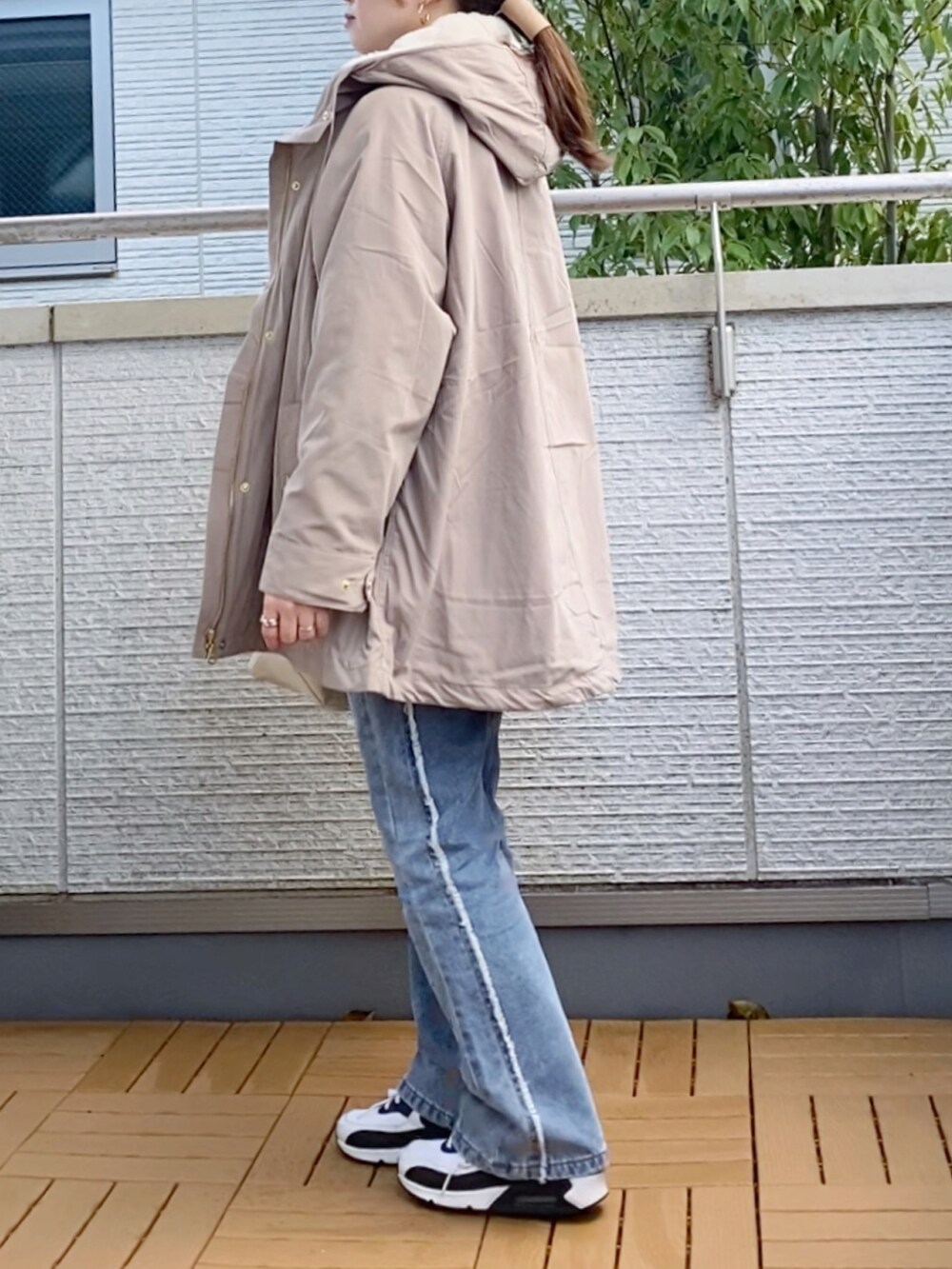 グレー系のニット/セーター、ブルー系のデニムパンツ、ホワイト系のトートバッグを着用したレディースの秋コーディネートの2枚目の写真