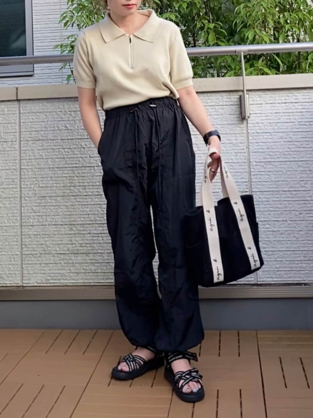 ホワイト系のTシャツ/カットソー、ブラック系のカーゴパンツ、ブラック系のトートバッグを着用したレディースの夏コーディネートの2枚目の写真