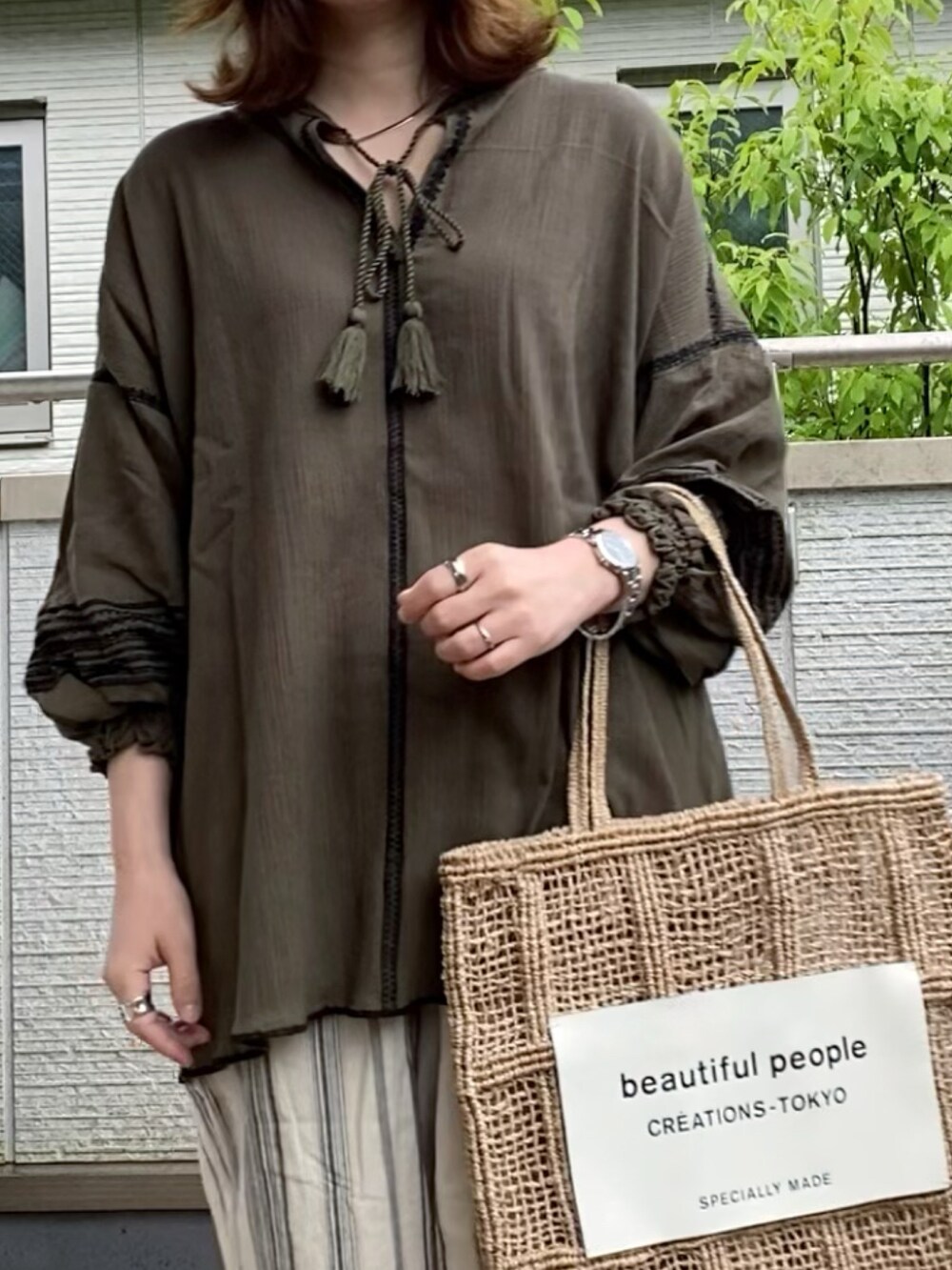 グリーン系のシャツ/ブラウス、ホワイト系のその他パンツ、ベージュ系のバッグを着用したレディースの夏コーディネートの2枚目の写真