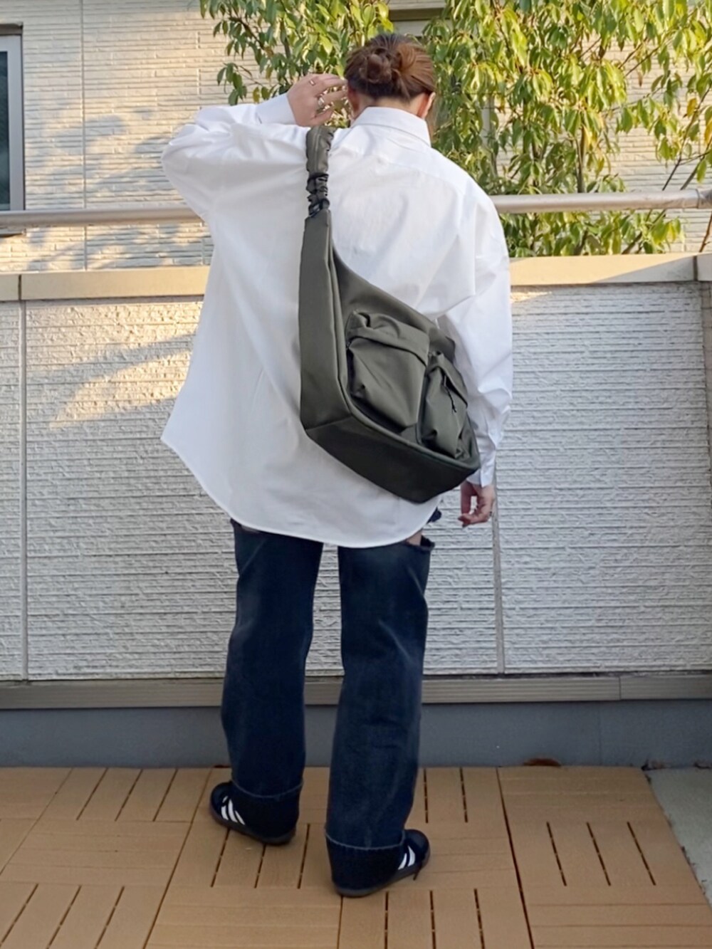 ホワイト系のシャツ/ブラウス、ブラック系のデニムパンツ、グリーン系のショルダーバッグを着用したレディースの春コーディネートの4枚目の写真