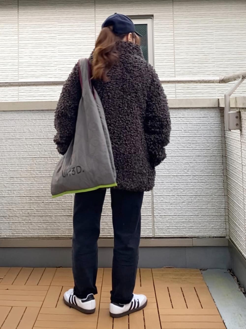 グレー系のブルゾン、ホワイト系のTシャツ/カットソー、グレー系のトートバッグを着用したレディースの秋コーディネートの4枚目の写真
