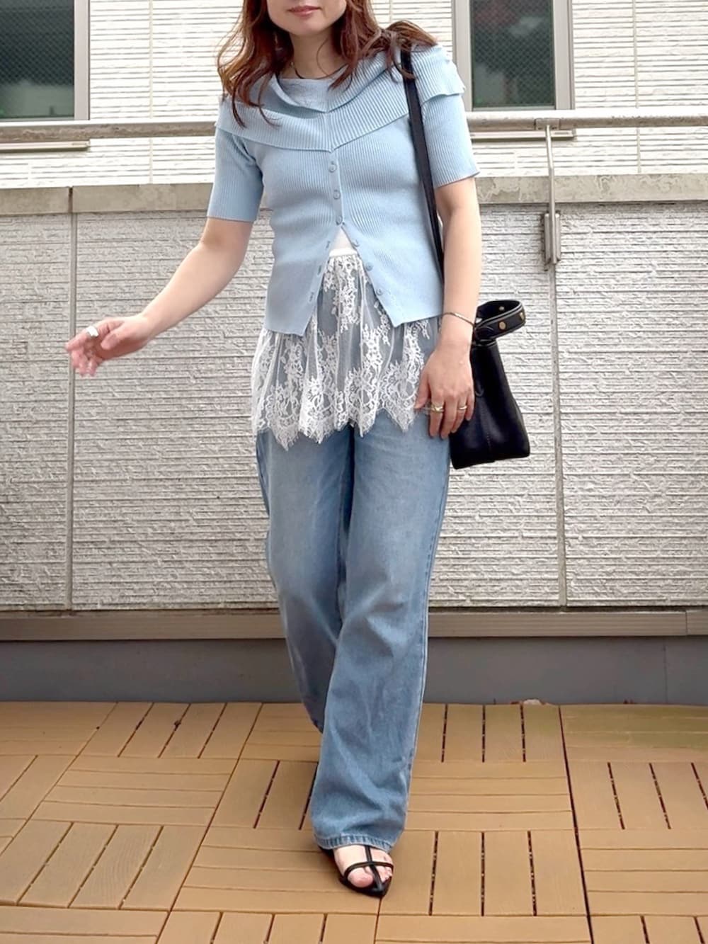 ブルー系のニット/セーター、ホワイト系のキャミソール、ブルー系のデニムパンツを着用したレディースの夏コーディネートの2枚目の写真