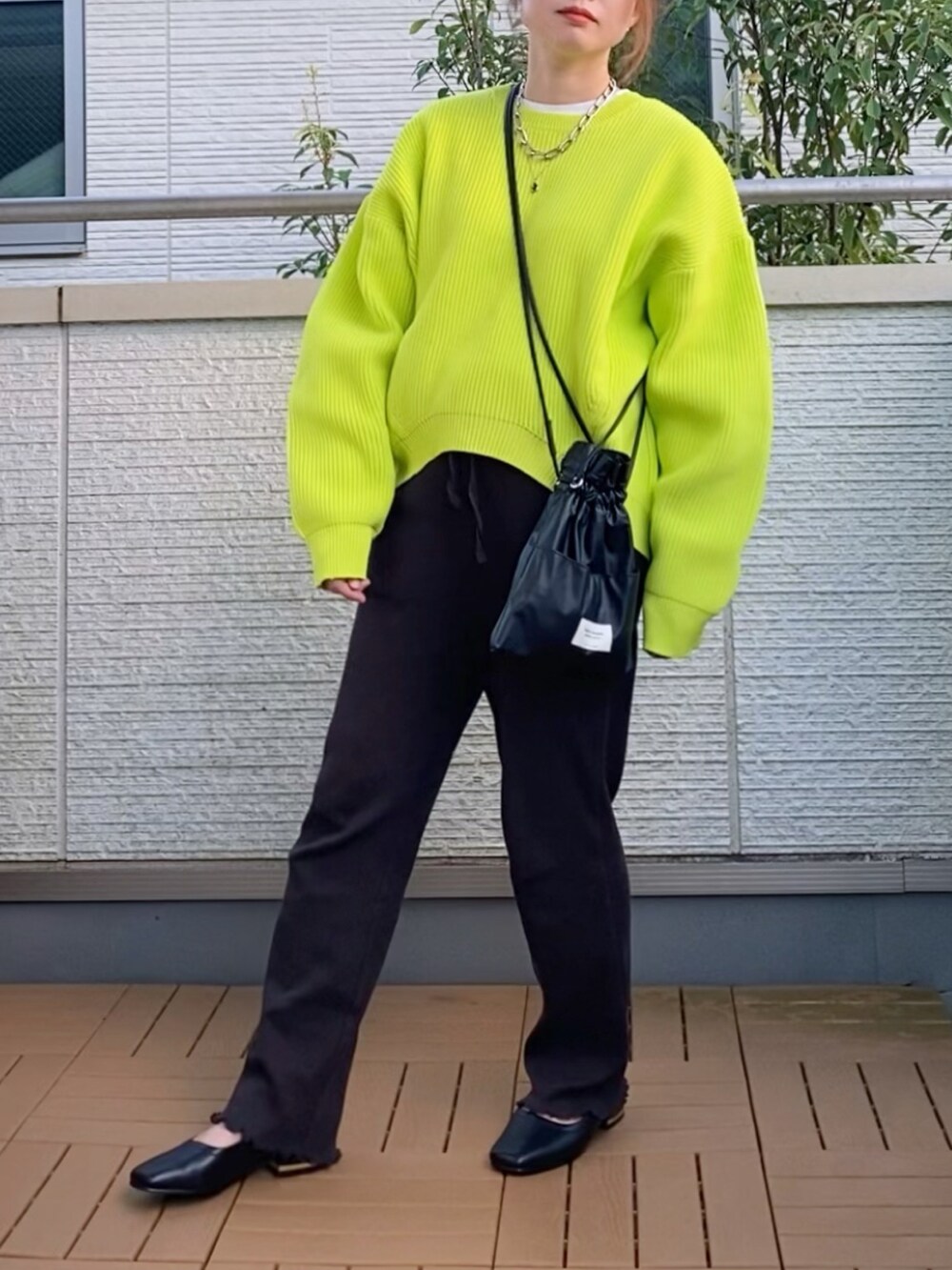 グリーン系のニット/セーター、ブラック系のその他パンツ、ブラック系のショルダーバッグを着用したレディースの秋コーディネートの3枚目の写真