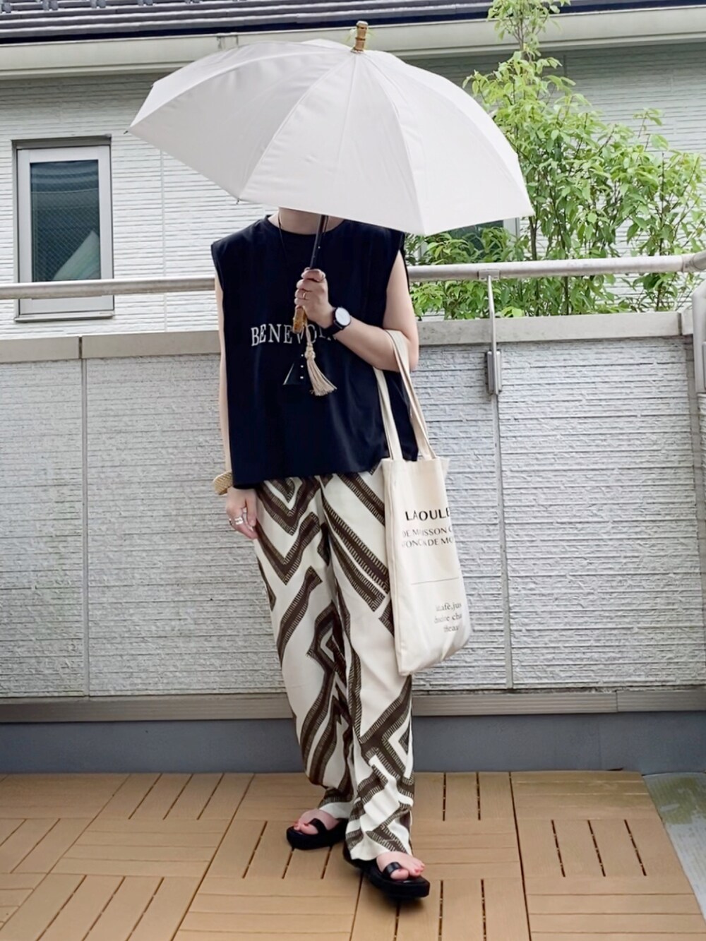 ブラック系のTシャツ/カットソー、ホワイト系のその他パンツ、ホワイト系のトートバッグを着用したレディースの夏コーディネートの2枚目の写真