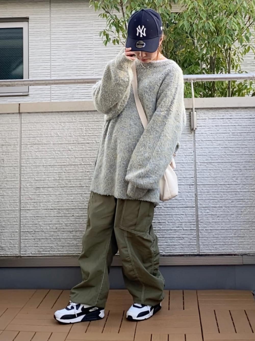 グレー系のカーディガン/ボレロ、グリーン系のカーゴパンツ、ホワイト系のトートバッグを着用したレディースの秋コーディネートの2枚目の写真