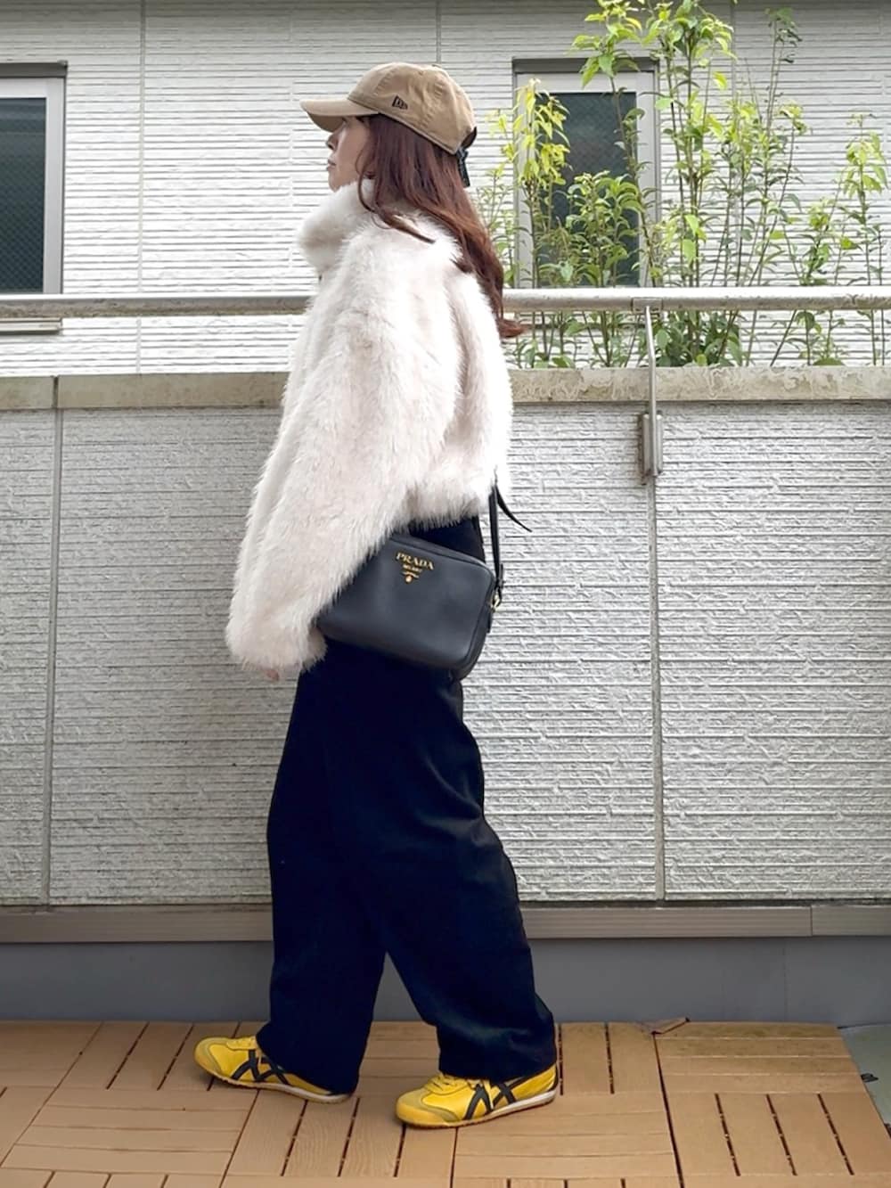 ホワイト系のブルゾン、ブラック系のその他パンツ、イエロー系のスニーカーを着用したレディースの秋コーディネートの3枚目の写真
