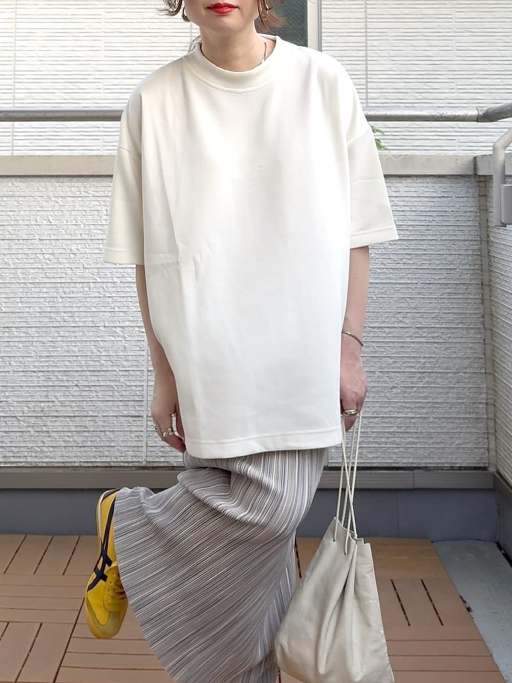 グレー系のスカート、ホワイト系のTシャツ/カットソー、イエロー系のスニーカーを着用したレディースの夏コーディネートの5枚目の写真