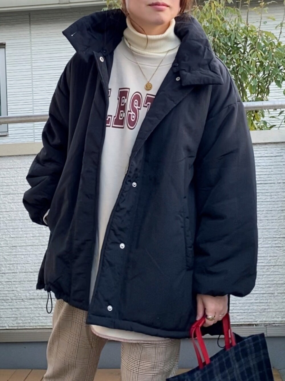 ブラック系のブルゾン、ホワイト系のニット/セーター、ベージュ系のスウェットを着用したレディースの冬コーディネートの2枚目の写真