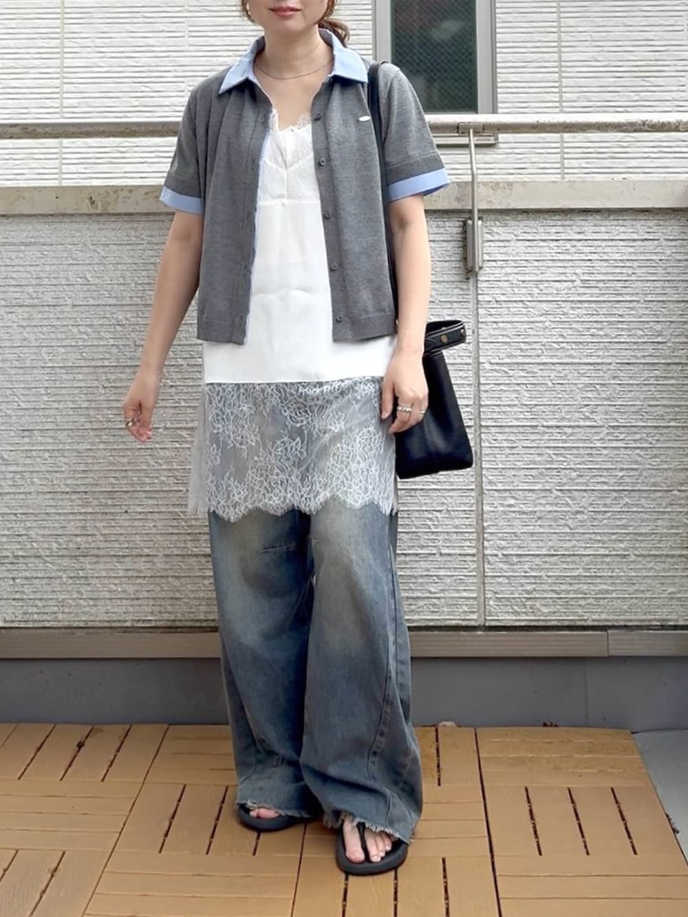 ホワイト系のキャミソール、ブルー系のデニムパンツ、グレー系のカーディガン/ボレロを着用したレディースの夏コーディネートの3枚目の写真