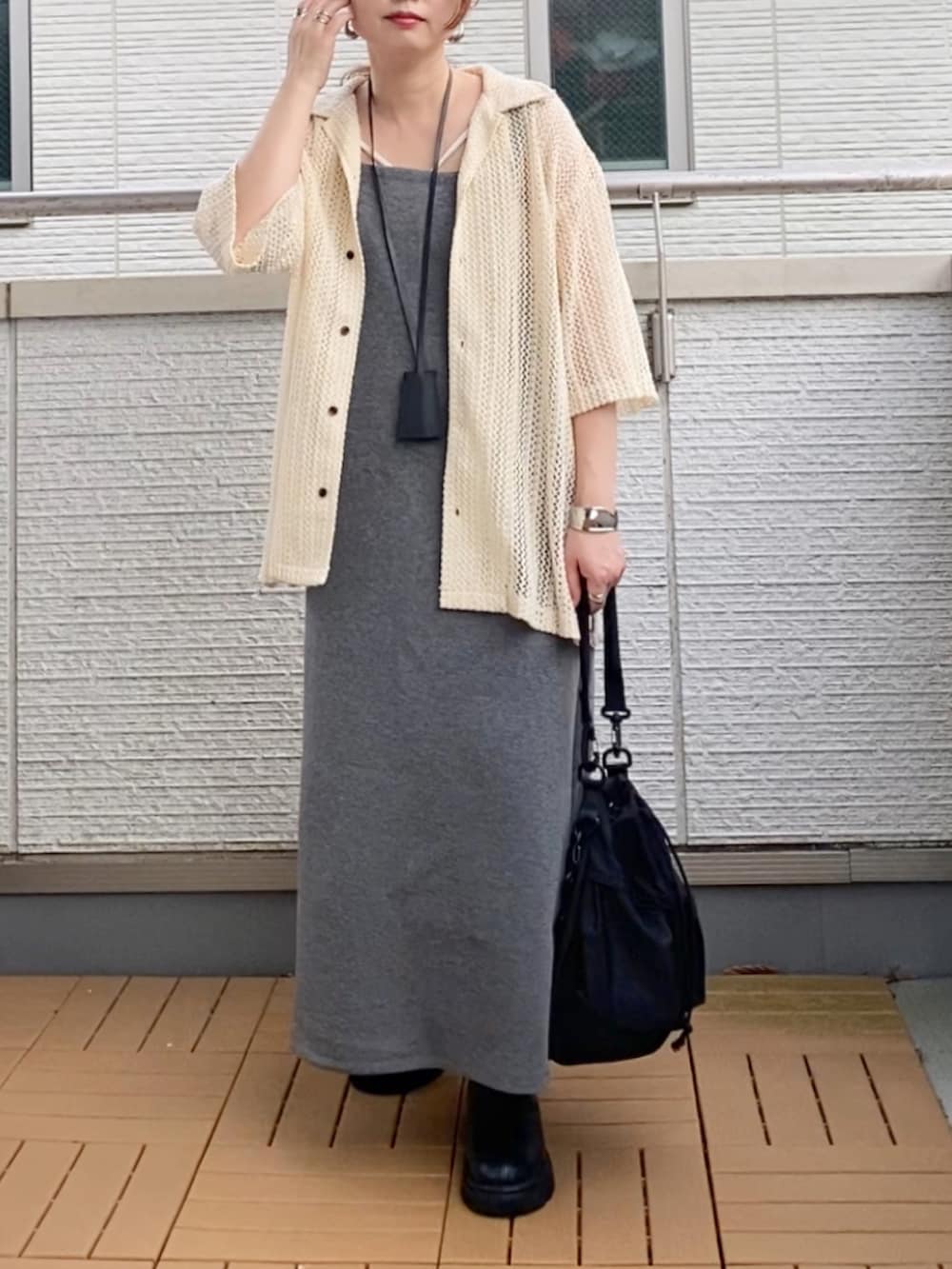 グレー系のワンピース、ホワイト系のシャツ/ブラウス、ブラック系のブーツを着用したレディースの夏コーディネートの2枚目の写真