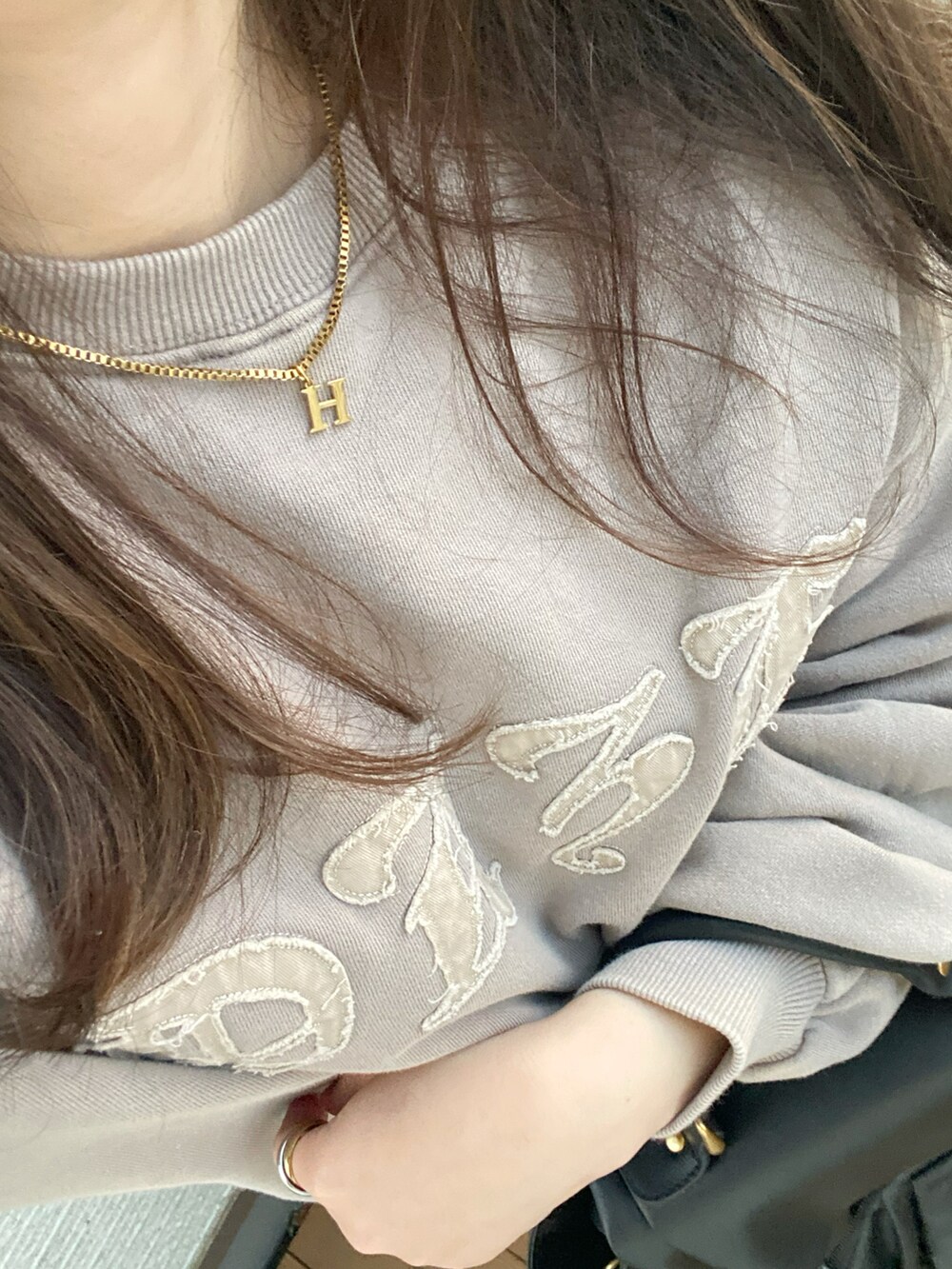 ベージュ系のトップス、ホワイト系のスカート、ブラック系のハンドバッグを着用したレディースの冬コーディネートの5枚目の写真