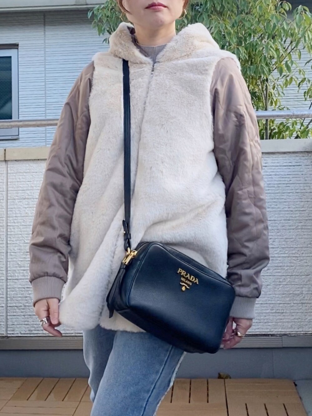 グレー系のニット/セーター、ブルー系のデニムパンツ、ホワイト系のトートバッグを着用したレディースの秋コーディネートの5枚目の写真