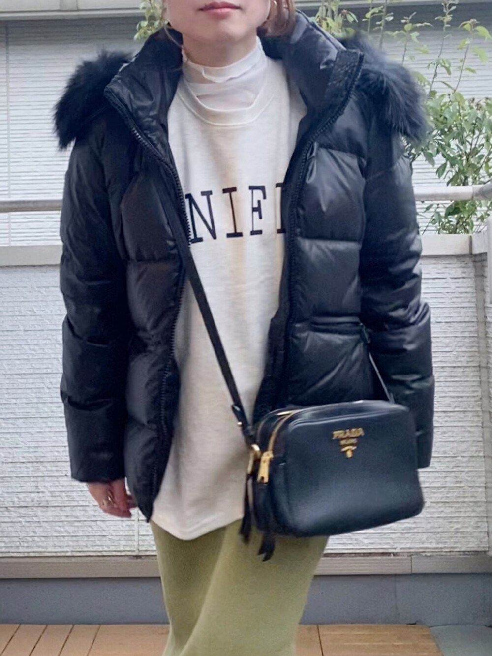 ブラック系のダウンジャケット/コート、ベージュ系のスウェット、グリーン系のスカートを着用したレディースの秋コーディネートの2枚目の写真