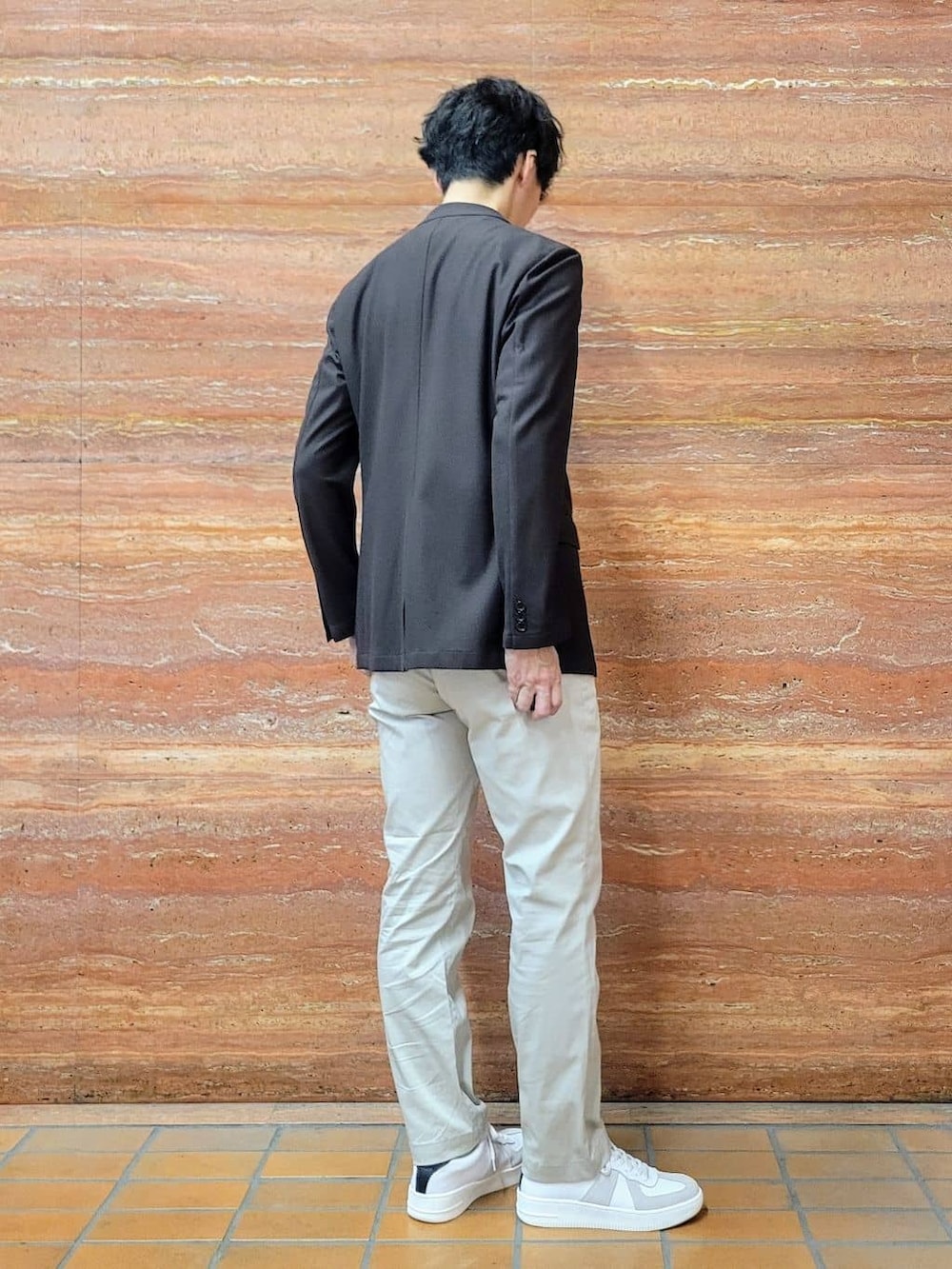 グリーン系のTシャツ/カットソー、ベージュ系のスラックス、ホワイト系のスニーカーを着用したメンズの春コーディネートの4枚目の写真