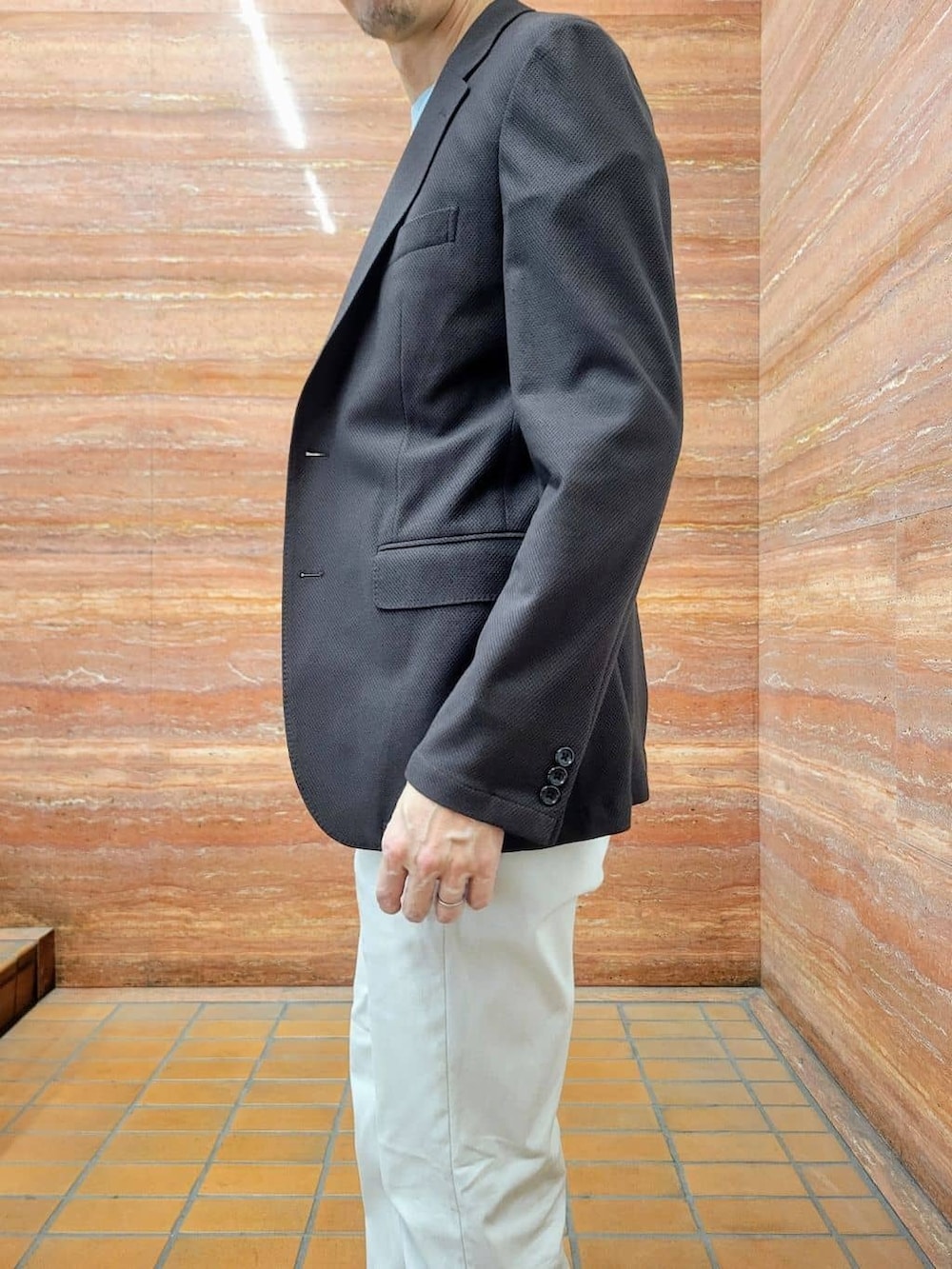 グリーン系のTシャツ/カットソー、ベージュ系のスラックス、ホワイト系のスニーカーを着用したメンズの春コーディネートの9枚目の写真
