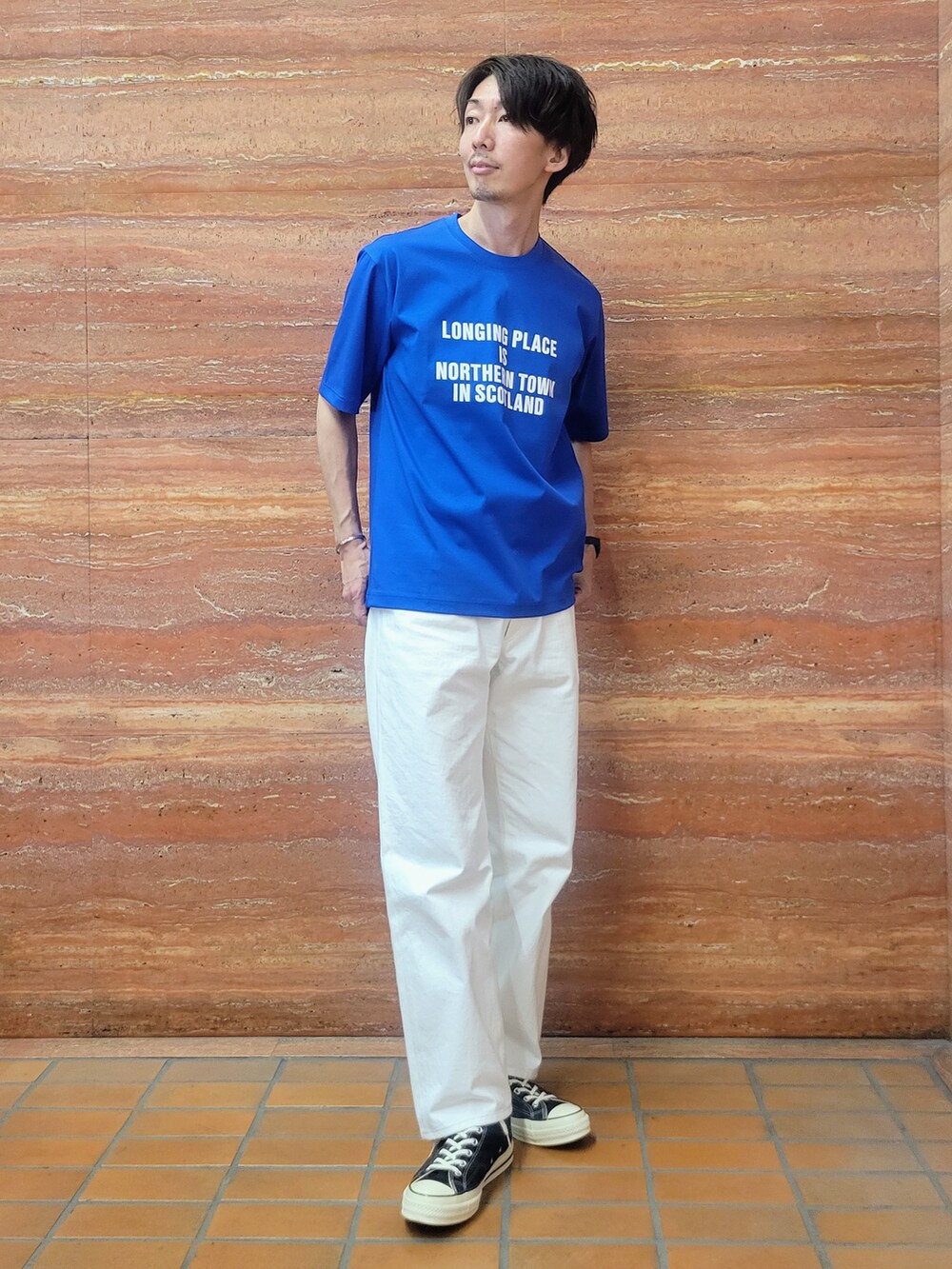ブルー系のTシャツ/カットソー、ホワイト系のデニムパンツを着用したメンズの春コーディネートの7枚目の写真