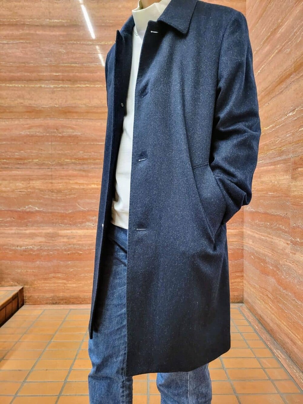 ブルー系のステンカラーコート、ホワイト系のTシャツ/カットソー、ブルー系のデニムパンツを着用したメンズの冬コーディネートの9枚目の写真