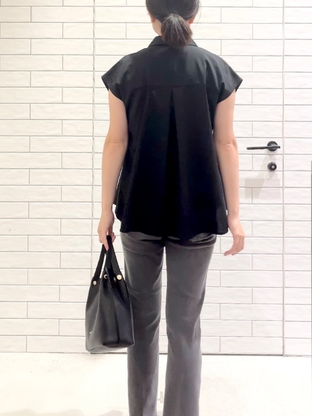 ブラック系のシャツ/ブラウス、グレー系のデニムパンツ、ブラック系のパンプスを着用したレディースの夏コーディネートの3枚目の写真