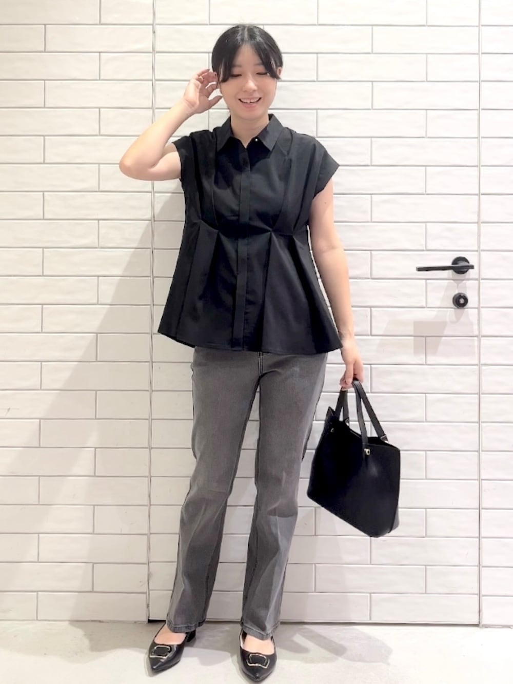 ブラック系のシャツ/ブラウス、グレー系のデニムパンツ、ブラック系のパンプスを着用したレディースの夏コーディネートの7枚目の写真