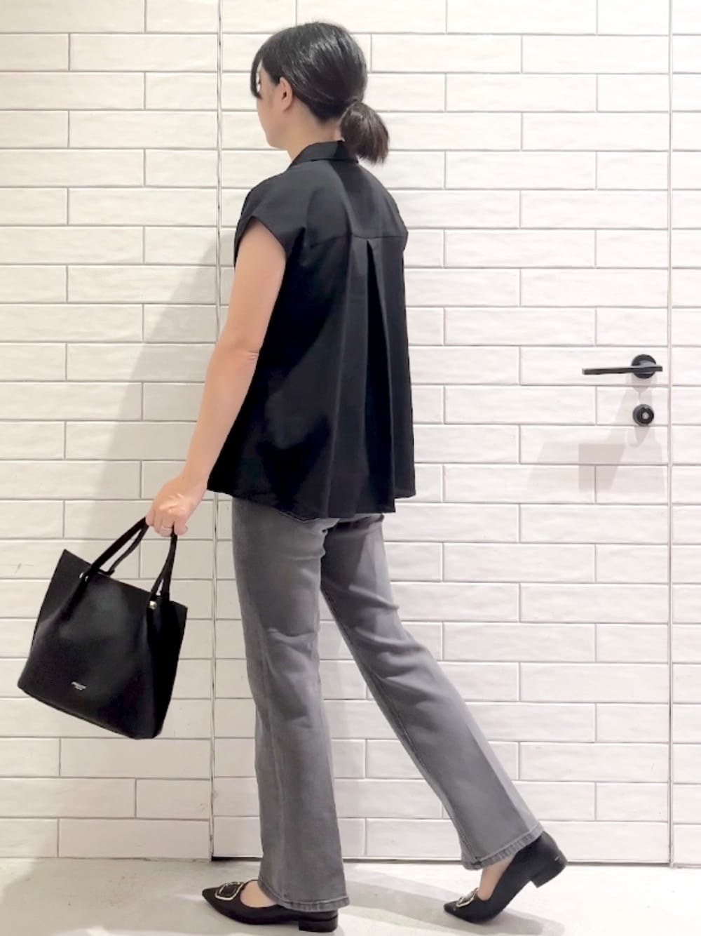 ブラック系のシャツ/ブラウス、グレー系のデニムパンツ、ブラック系のパンプスを着用したレディースの夏コーディネートの5枚目の写真