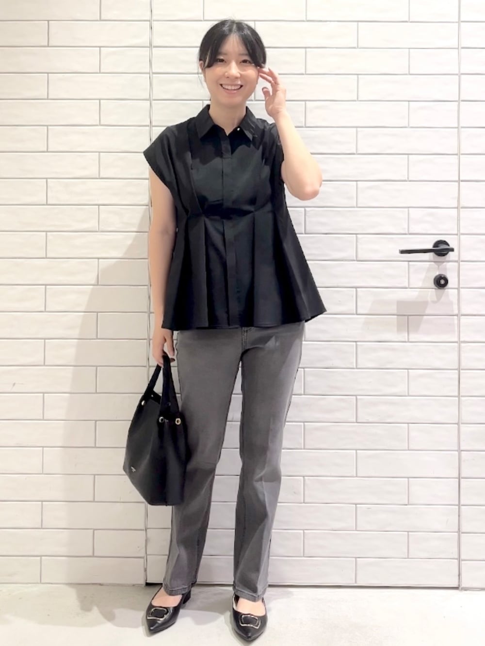 ブラック系のシャツ/ブラウス、グレー系のデニムパンツ、ブラック系のパンプスを着用したレディースの夏コーディネートの8枚目の写真
