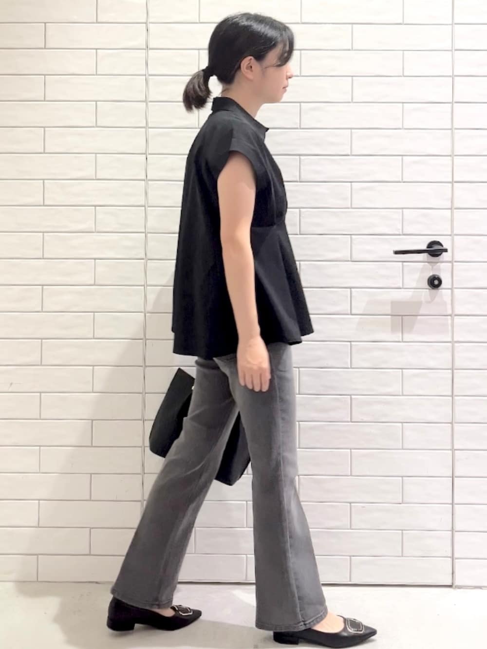 ブラック系のシャツ/ブラウス、グレー系のデニムパンツ、ブラック系のパンプスを着用したレディースの夏コーディネートの4枚目の写真