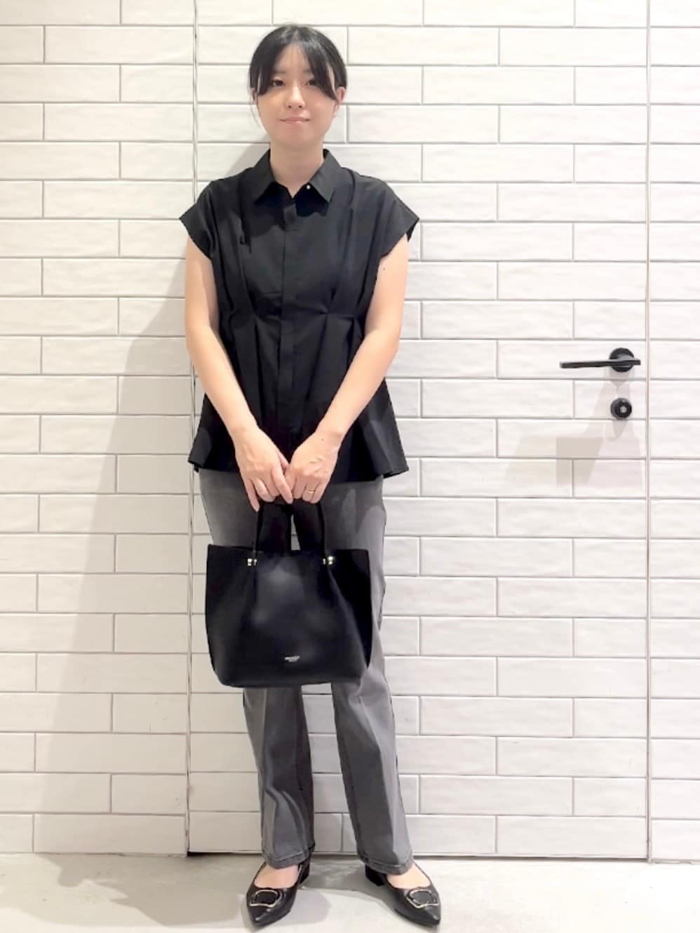 ブラック系のシャツ/ブラウス、グレー系のデニムパンツ、ブラック系のパンプスを着用したレディースの夏コーディネートの6枚目の写真