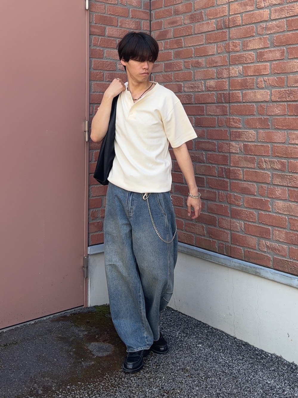 ホワイト系のTシャツ/カットソー、ブルー系のデニムパンツ、ブラック系のトートバッグを着用したメンズの春コーディネートの3枚目の写真