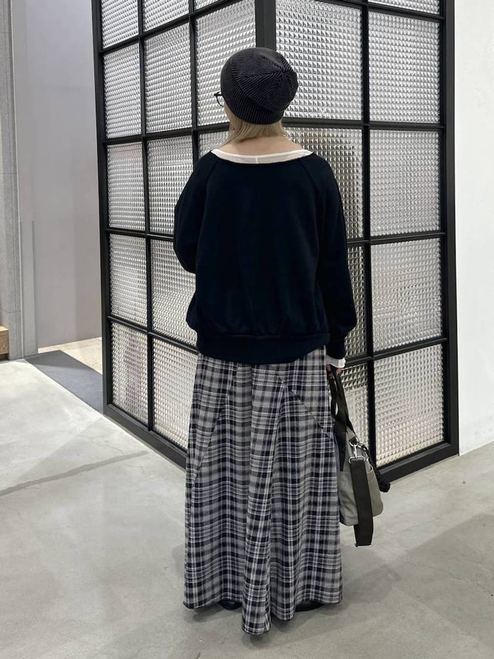 グレー系のスカート、ブラック系のその他トップス、グリーン系のショルダーバッグを着用したレディースの秋コーディネートの4枚目の写真