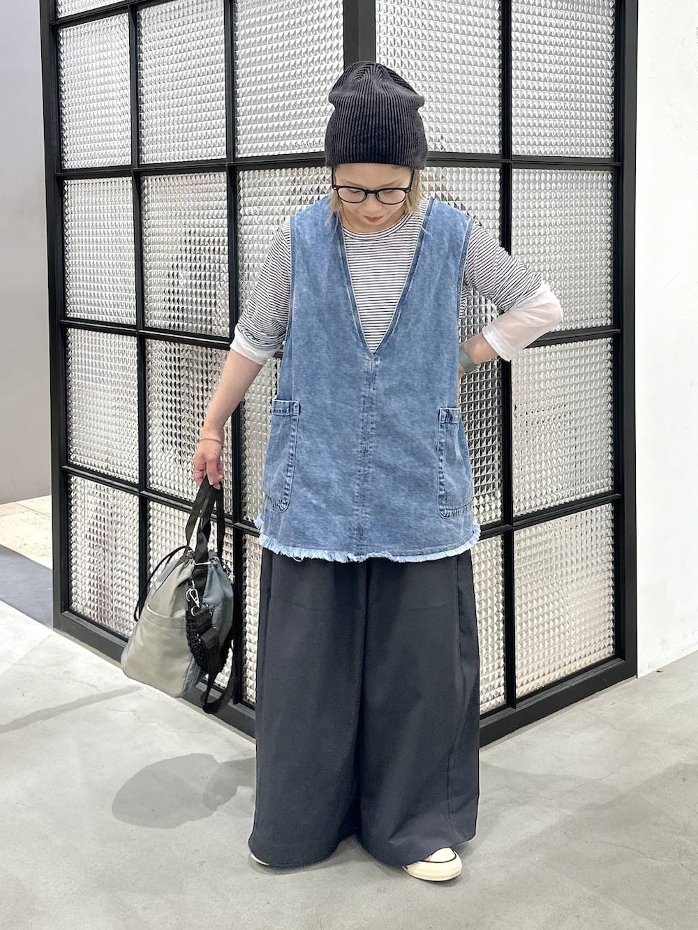 ブルー系のベスト、ホワイト系のTシャツ/カットソー、グリーン系のショルダーバッグを着用したレディースの夏コーディネートの2枚目の写真