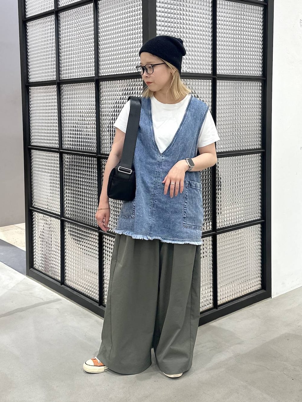 ブラック系のショルダーバッグ、ブルー系のベスト、グリーン系のその他パンツを着用したレディースの夏コーディネートの3枚目の写真