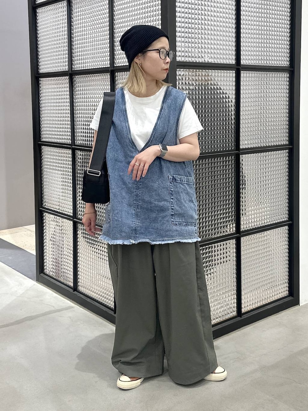 ブラック系のショルダーバッグ、ブルー系のベスト、グリーン系のその他パンツを着用したレディースの夏コーディネートの2枚目の写真