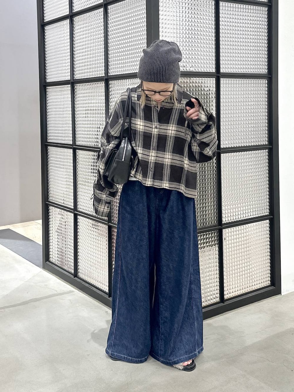 ブラック系のシャツ/ブラウス、グレー系のサンダル、ブラック系のボストンバッグを着用したレディースの夏コーディネートの2枚目の写真